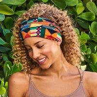 Woman with curly hair looking down, wearing the Multi-Use Beauty Band folded as a headband