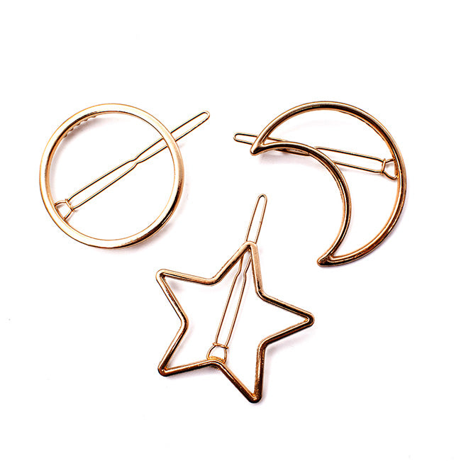Three gold-tone Soulmates hair clips shaped like a circle, crescent moon, and star, each with a straight bar clasp