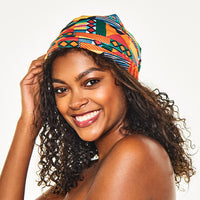 Smiling woman wearing the Multi-Use Beauty Band as a head wrap, with her curly hair down