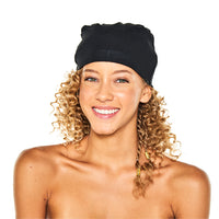 Smiling woman with curly hair wearing the black Satin-Lined Jersey Beanie, facing forward