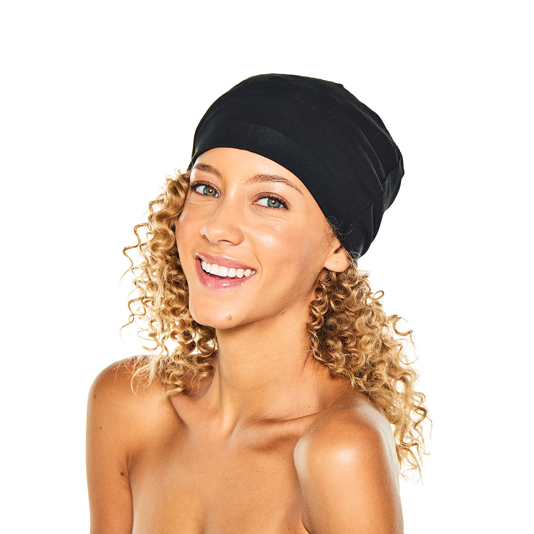 Smiling woman with curly hair wearing the black Satin-Lined Jersey Beanie